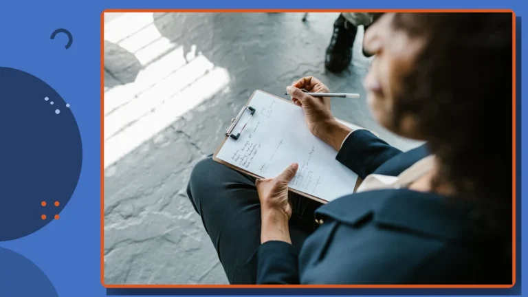 A psychologist taking notes on a clipboard during a session.