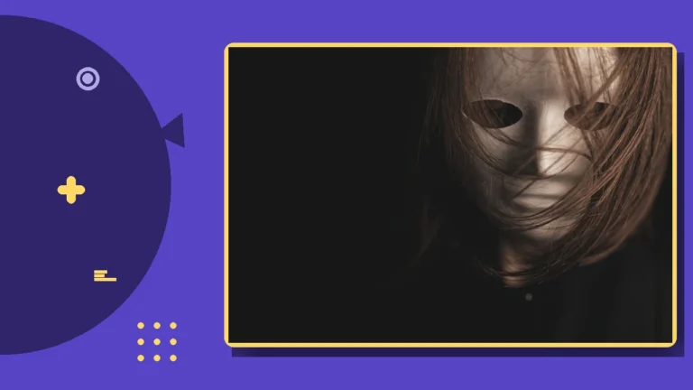 A theatrical mask resting in shadow on a dark surface.