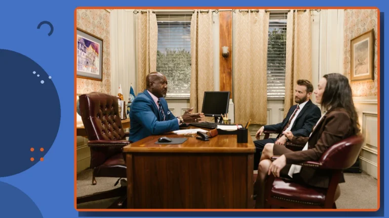 An attorney meeting with clients across a desk in a law office.